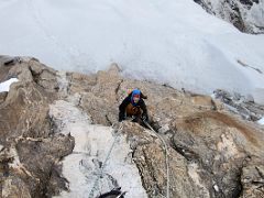 05B Climbing one last large rock assisted by hand ropes before reaching the snow slopes on Lobuche East Peak summit climb