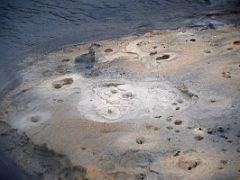 05C Bubbling mud pots with boiling hot water flowing by at Seltun Krysuvík geothermal area Reykjanes Peninsula Iceland