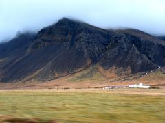 01B Mount Esjan in the clouds with some buildings in the foreground on the drive from Reykjavik to Snaefellsnes Iceland