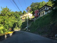 01B We weave our way up the hill passing colourful houses on our way to Blue Mountains near Kingston Jamaica