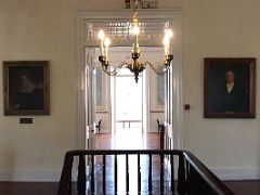 08B The stairway hall on the second floor at the top of the stairs has a decorative chandelier Devon House mansion Kingston Jamaica
