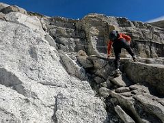 06B Starting the climb of the the steep rocky boulder slabs using a hand rope on the way to Lobuche East High Camp 5600m