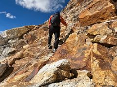 10A Starting to climb the traverse to the ridge on steep red rocky boulder slabs with hand ropes on the way to Lobuche East High Camp 5600m