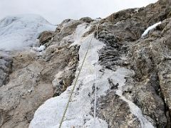 05C Looking up at the end of the hand ropes to climb one last large rock before reaching the snow slopes on Lobuche East Peak summit climb