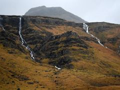 01A Narrow long waterfalls fall off the mountains driving on road 54 after leaving Grundarfjordur Snaefellsnes Peninsula Iceland